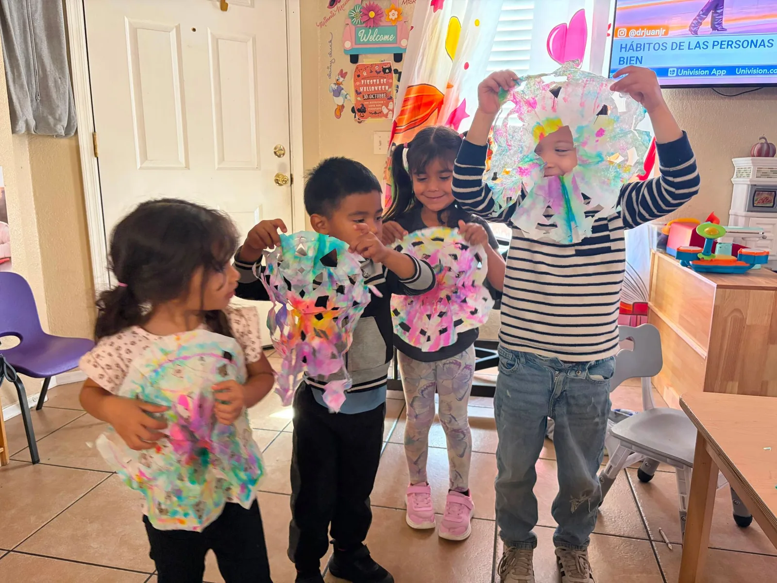 Children holding up the colorful paper crafts they made