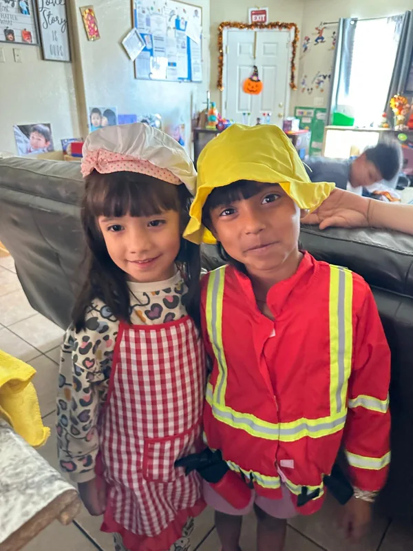 Two children in chef and firefighter costumes on dress-up day