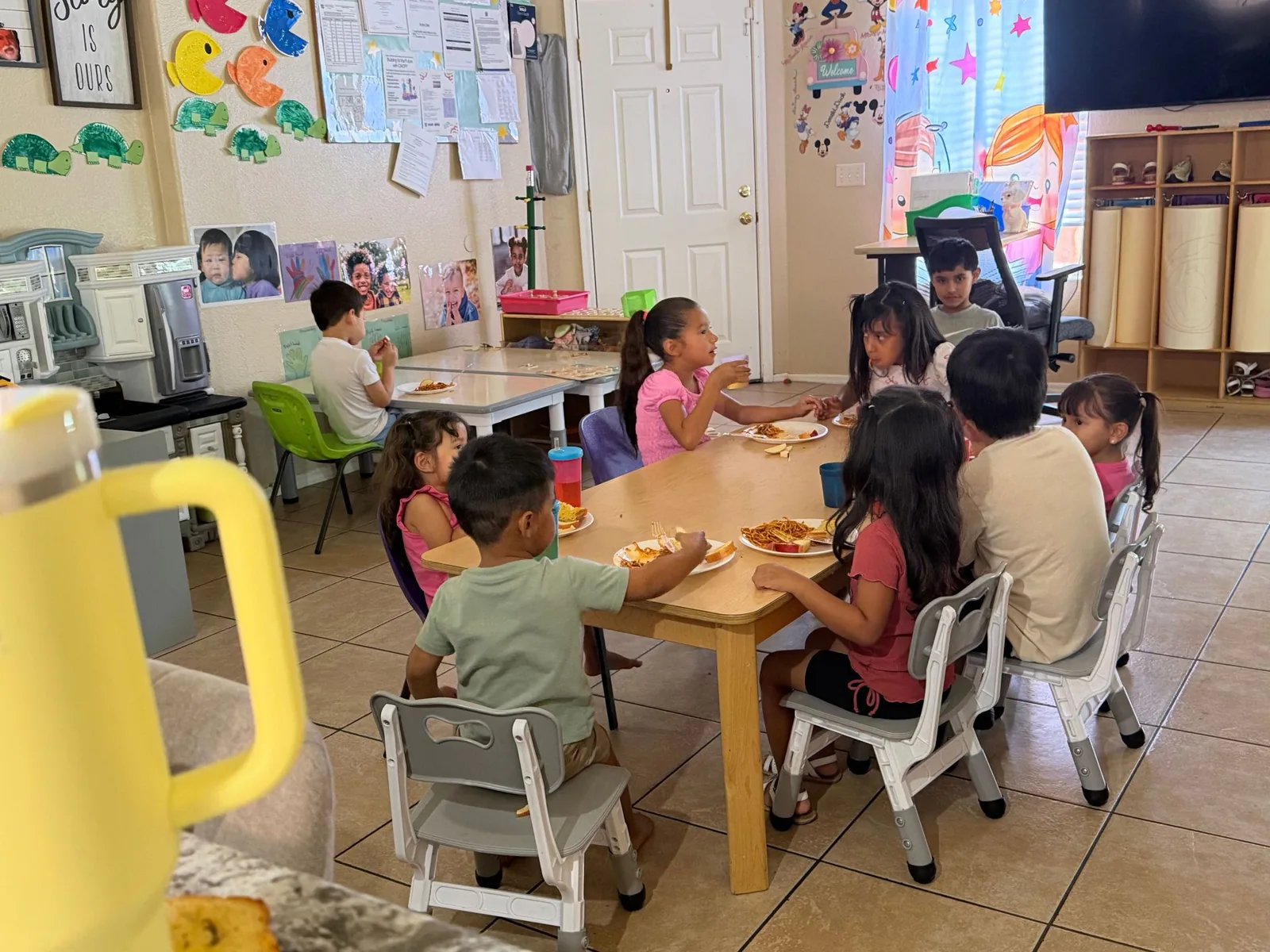 Children eating lunch together at the table in the playroom